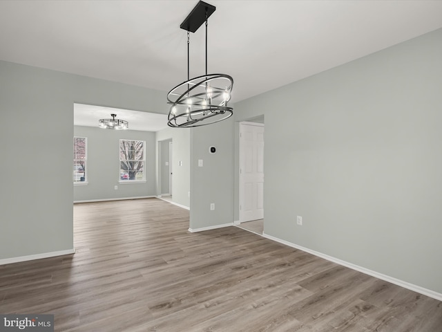 4300 Cullowhee Ct, Clinton, MD 20735 - unfurnished dining area featuring a chandelier, wood finished floors, and baseboards