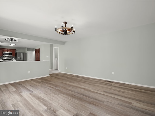 4300 Cullowhee Ct, Clinton, MD 20735 - unfurnished living room featuring a chandelier, wood finished floors, and baseboards