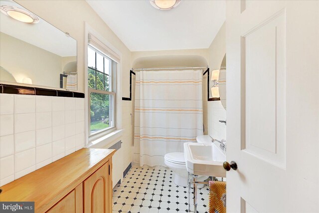 29 S Rockburn St, York, PA 17402 - bathroom featuring toilet, a sink, curtained shower, tile walls, and radiator