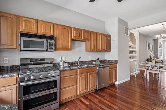 424 N Luzerne Ave N, Baltimore, MD 21224 - kitchen featuring stainless steel appliances, a sink, decorative backsplash, dark wood-style floors, and a chandelier