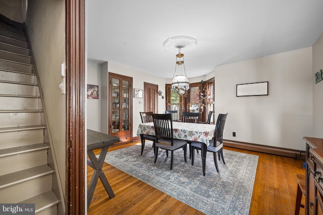 19 W Ave, Woodstown, NJ 08098 - dining room featuring a baseboard radiator, stairway, wood finished floors, a chandelier, and baseboards