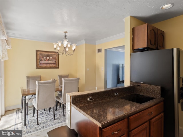4807 Kempair Ct, Woodbridge, VA 22193 - kitchen featuring freestanding refrigerator, a chandelier, crown molding, dark stone countertops, and hanging light fixtures
