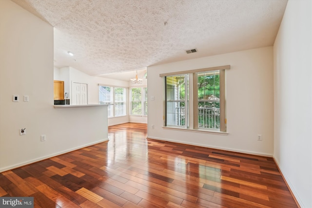 9763 Reese Farm Rd Unit 9763, Owings Mills, MD 21117 - unfurnished living room featuring a textured ceiling, a chandelier, hardwood / wood-style flooring, baseboards, and vaulted ceiling