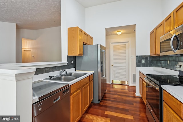 9763 Reese Farm Rd Unit 9763, Owings Mills, MD 21117 - kitchen featuring stainless steel appliances, a sink, dark wood-type flooring, backsplash, and a textured ceiling