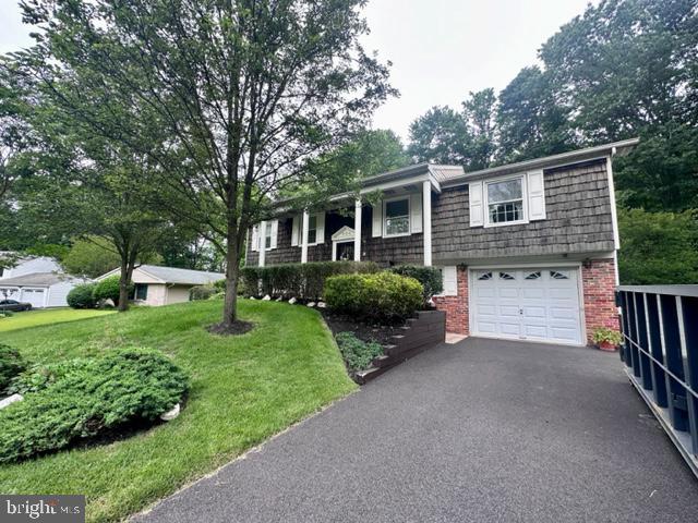 304 Blackburn Ct, Joppa, MD 21085 - bi-level home with brick siding, asphalt driveway, a garage, mansard roof, and a front lawn