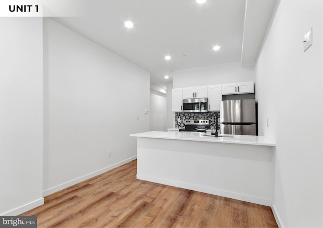 1150 S 52nd St, Philadelphia, PA 19143 - kitchen with appliances with stainless steel finishes, tasteful backsplash, white cabinetry, light wood-type flooring, and recessed lighting