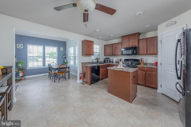 7 Schooner, Carneys Point, NJ 08069 - kitchen with black appliances, a center island, a ceiling fan, and brown cabinets