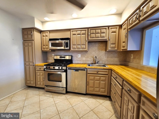 5100 Convent Ln Unit 412, Philadelphia, PA 19114 - kitchen featuring appliances with stainless steel finishes, wooden counters, a sink, backsplash, and light tile patterned floors