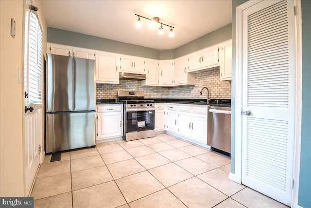 113 Wilgate Rd, Owings Mills, MD 21117 - kitchen featuring stainless steel appliances, under cabinet range hood, dark countertops, backsplash, and light tile patterned flooring