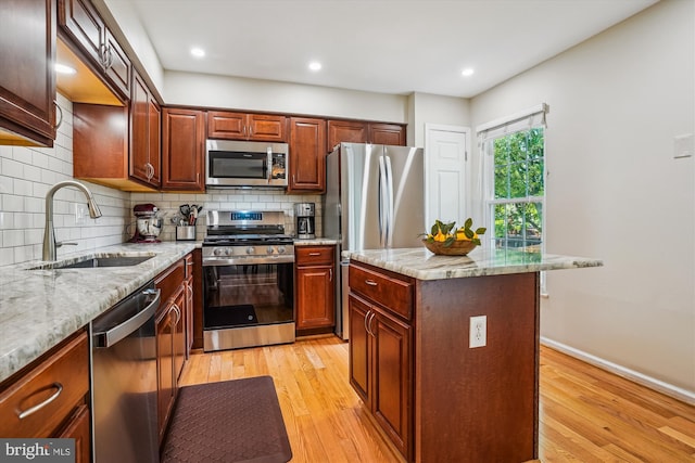 7484 Gadsby Sq, Alexandria, VA 22315 - kitchen with appliances with stainless steel finishes, a sink, tasteful backsplash, light wood finished floors, and light stone counters