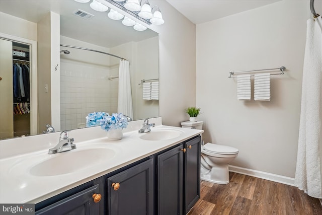 7484 Gadsby Sq, Alexandria, VA 22315 - full bathroom with double vanity, wood finished floors, toilet, curtained shower, and baseboards