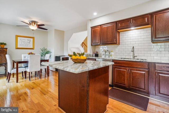 7484 Gadsby Sq, Alexandria, VA 22315 - kitchen featuring a sink, a center island, tasteful backsplash, light wood finished floors, and stainless steel dishwasher