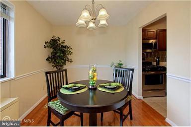 3515 Washington Blvd Unit 310, Arlington, VA 22201 - dining room featuring a chandelier, light wood-style floors, and baseboards