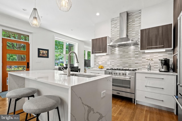1401 S Carolina Ave SE Unit 1, Washington, DC 20003 - kitchen featuring wall chimney range hood, high end stove, modern cabinets, decorative backsplash, and recessed lighting