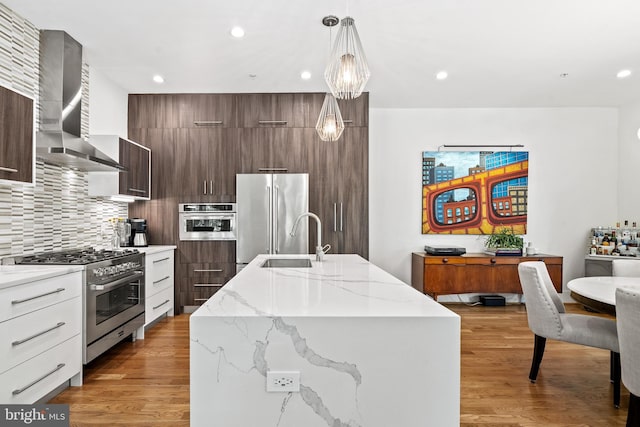 1401 S Carolina Ave SE Unit 1, Washington, DC 20003 - kitchen featuring wall chimney exhaust hood, high quality appliances, modern cabinets, an island with sink, and hanging light fixtures