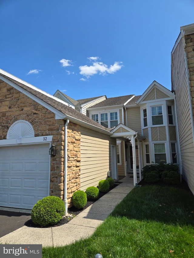 32 Hunters Way W, Newtown, PA 18940 - townhome / multi-family property with stone siding, a garage, and roof with shingles