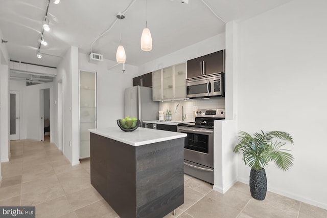 2311 M St NW Unit Ph-1007, Washington, DC 20037 - kitchen featuring stainless steel appliances, a kitchen island, light countertops, rail lighting, and decorative backsplash