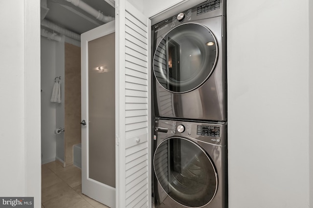 2311 M St NW Unit Ph-1007, Washington, DC 20037 - laundry area featuring stacked washer / dryer, tile patterned flooring, and baseboards