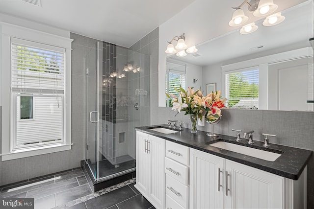 2811 35th St NW, Washington, DC 20007 - full bath with a shower stall, double vanity, a chandelier, decorative backsplash, and tile patterned floors