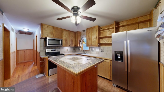 6085 Mud Mill Rd, Camden Wyoming, DE 19934 - kitchen featuring stainless steel appliances, open shelves, tile counters, a center island, and a wainscoted wall