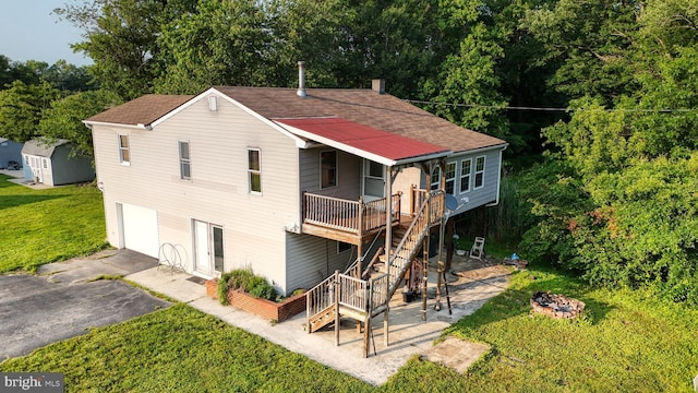 6085 Mud Mill Rd, Camden Wyoming, DE 19934 - back of property featuring an outdoor fire pit, asphalt driveway, a garage, a lawn, and stairway