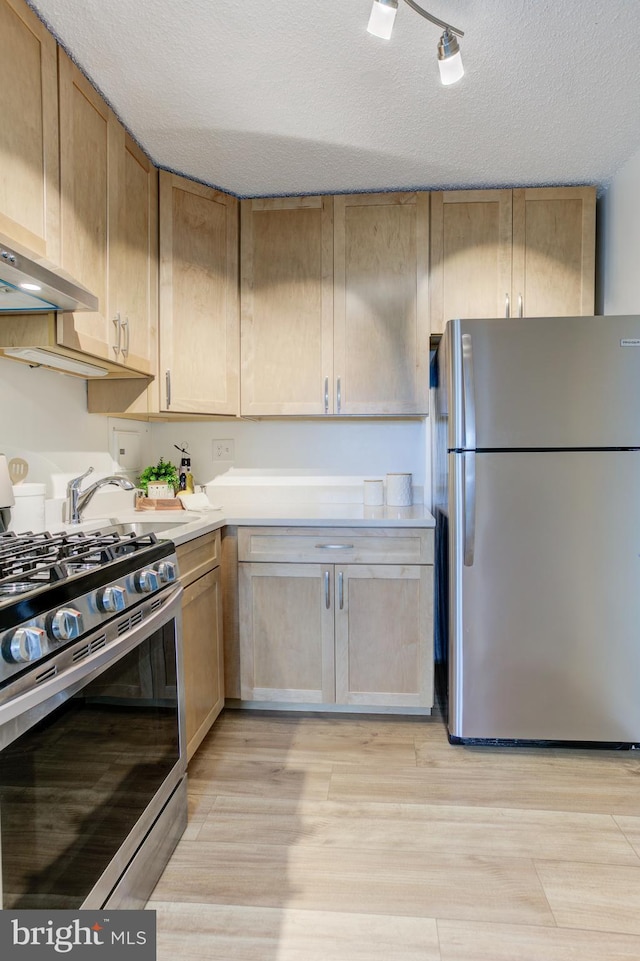 1225 Martha Custis Dr Unit 904, Alexandria, VA 22302 - kitchen with stainless steel appliances, light wood-type flooring, a textured ceiling, light countertops, and wall chimney exhaust hood
