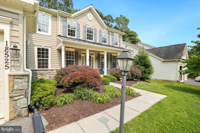18525 Rushbrooke Dr, Olney, MD 20832 - view of front facade with a front yard, covered porch, stone siding, and a standing seam roof