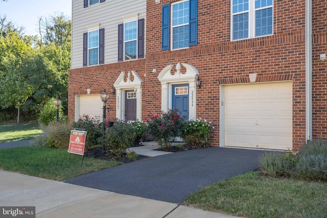 22864 Chestnut Oak Ter, Sterling, VA 20166 - view of front of house with an attached garage, brick siding, and driveway