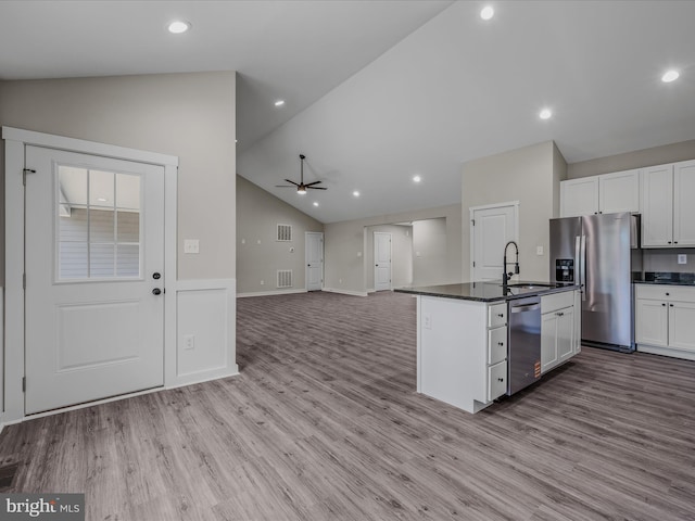 39 Mdg, Berkeley Springs, WV 25411 - kitchen featuring appliances with stainless steel finishes, a sink, dark countertops, lofted ceiling, and white cabinetry