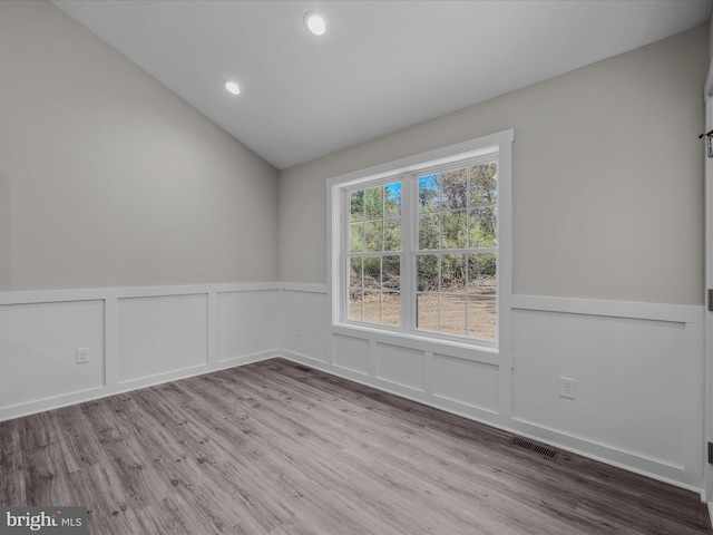 39 Mdg, Berkeley Springs, WV 25411 - empty room with wood finished floors, wainscoting, a decorative wall, vaulted ceiling, and recessed lighting