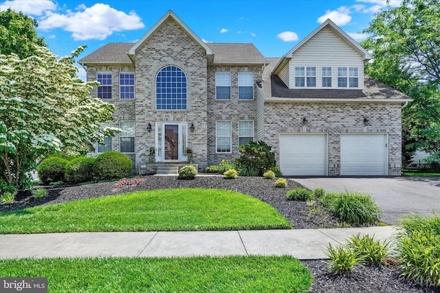 1215 Oakwood Ln, York, PA 17403 - colonial-style house featuring driveway, an attached garage, a front lawn, and brick siding