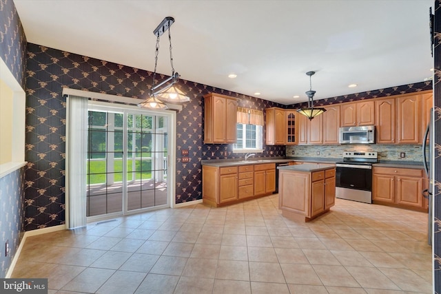 1215 Oakwood Ln, York, PA 17403 - kitchen featuring stainless steel appliances, wallpapered walls, light tile patterned floors, a kitchen island, and baseboards