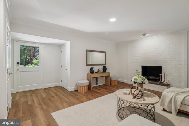 3233 Ellicott St NW, Washington, DC 20008 - living area featuring wood finished floors, crown molding, a brick fireplace, baseboards, and recessed lighting