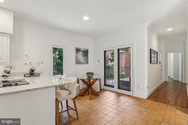 3233 Ellicott St NW, Washington, DC 20008 - kitchen with white cabinetry, black electric cooktop, recessed lighting, light tile patterned floors, and a kitchen bar