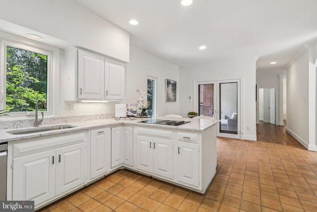 3233 Ellicott St NW, Washington, DC 20008 - kitchen with a sink, a peninsula, black electric stovetop, white cabinetry, and light tile patterned floors