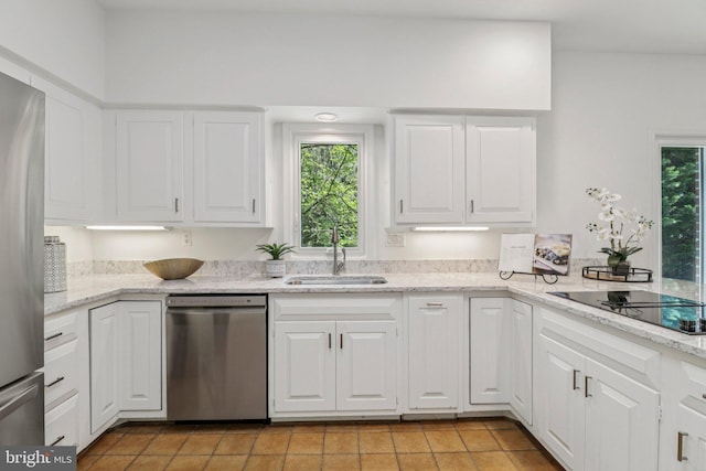 3233 Ellicott St NW, Washington, DC 20008 - kitchen with appliances with stainless steel finishes, a sink, light tile patterned floors, and white cabinets