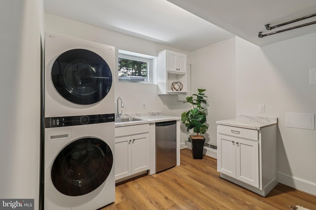 3233 Ellicott St NW, Washington, DC 20008 - laundry area featuring stacked washer and clothes dryer, light wood finished floors, and baseboards