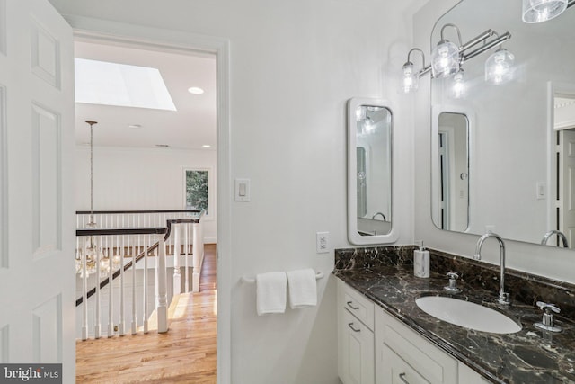 3233 Ellicott St NW, Washington, DC 20008 - bathroom with a skylight, vanity, and wood finished floors