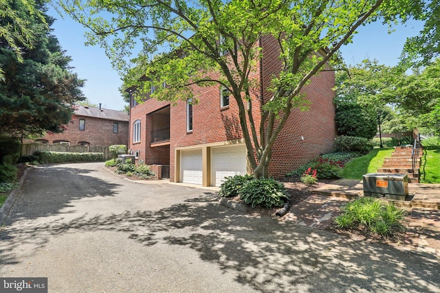 3233 Ellicott St NW, Washington, DC 20008 - view of home's exterior with asphalt driveway, brick siding, and a garage