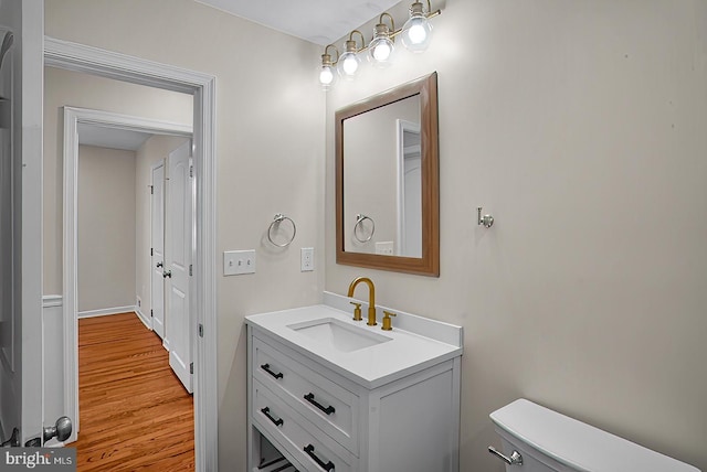 3316 Fairview Rd, Baltimore, MD 21207 - half bathroom featuring vanity, toilet, and wood finished floors