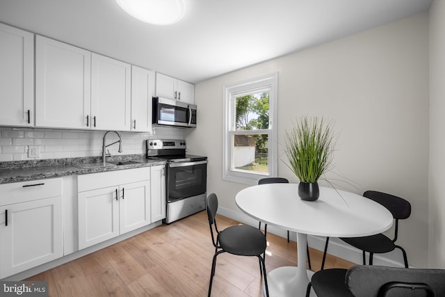 5600 Patrick Henry, Baltimore, MD 21225 - kitchen featuring appliances with stainless steel finishes, a sink, backsplash, white cabinetry, and baseboards