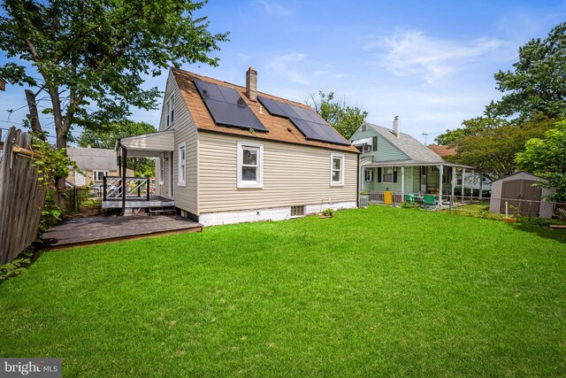 5600 Patrick Henry, Baltimore, MD 21225 - rear view of house featuring solar panels, a chimney, a wooden deck, and a shingled roof