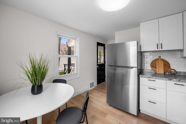 5600 Patrick Henry, Baltimore, MD 21225 - kitchen featuring freestanding refrigerator, light wood-type flooring, decorative backsplash, and white cabinetry