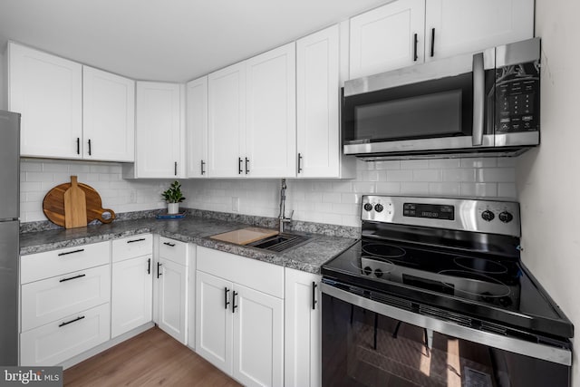 5600 Patrick Henry, Baltimore, MD 21225 - kitchen with appliances with stainless steel finishes, a sink, white cabinets, and decorative backsplash