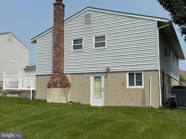 2 Renai Ct, Newark, DE 19702 - back of property featuring a lawn, a chimney, central air condition unit, and stucco siding