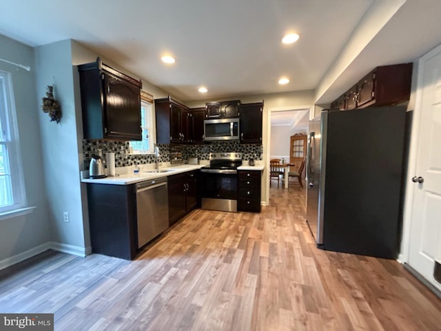 39410 Thomas Dr, Mechanicsville, MD 20659 - kitchen with appliances with stainless steel finishes, a sink, light wood-style floors, light countertops, and tasteful backsplash