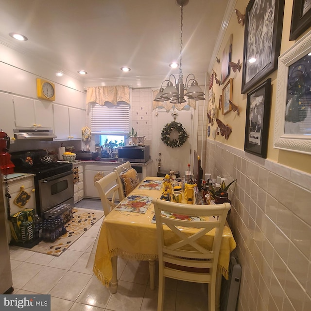 1115 Bentalou St, Baltimore, MD 21216 - dining space with light tile patterned flooring, crown molding, a chandelier, and tile walls