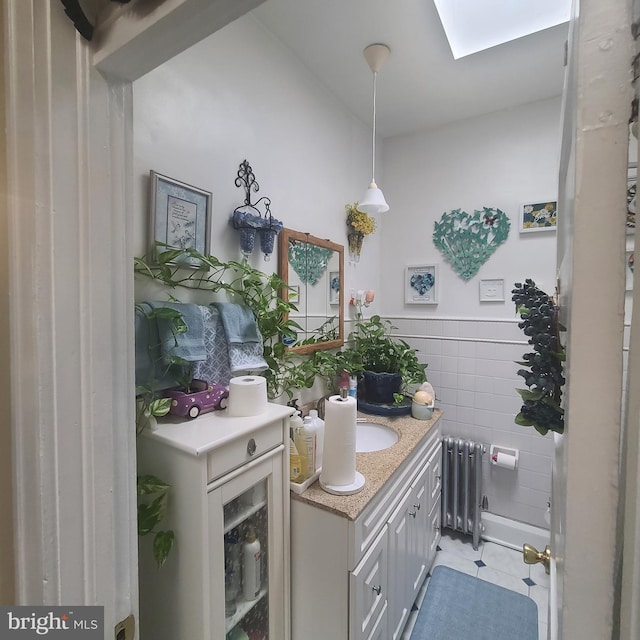 1115 Bentalou St, Baltimore, MD 21216 - bathroom featuring radiator, vanity, tile patterned flooring, tile walls, and wainscoting