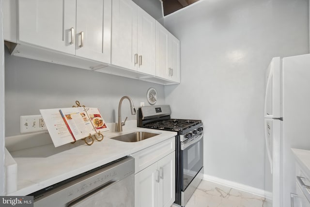 4379 Americana Dr Unit 201, Annandale, VA 22003 - kitchen with appliances with stainless steel finishes, light marble finish flooring, a sink, and white cabinets