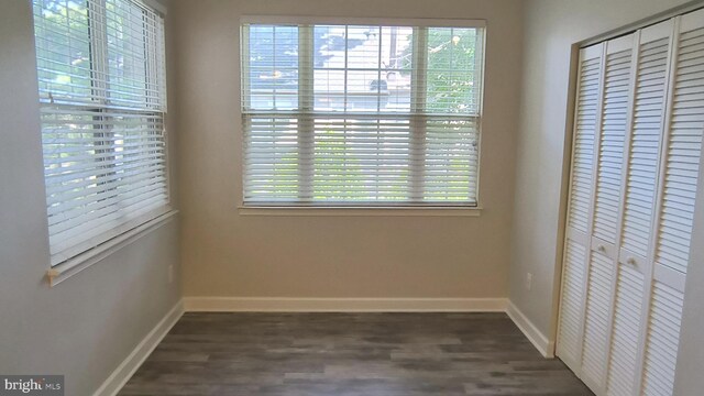 602 Moonglow Rd Unit 202, Odenton, MD 21113 - unfurnished bedroom with a closet, multiple windows, and dark wood-style flooring